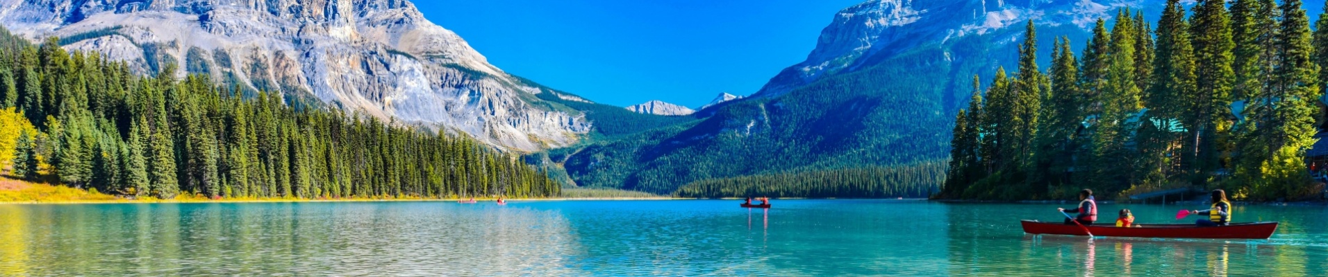 famille-traversant-lac-transparent-kayak-parc-banff-alberta