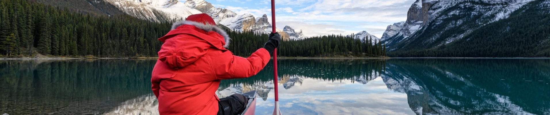 homme-assis-canoe-rive-lac-banff-canada