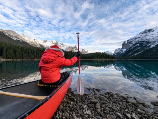homme-assis-canoe-rive-lac-banff-canada